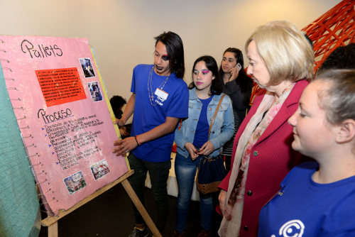 Ministra observando libro con los estudiantes